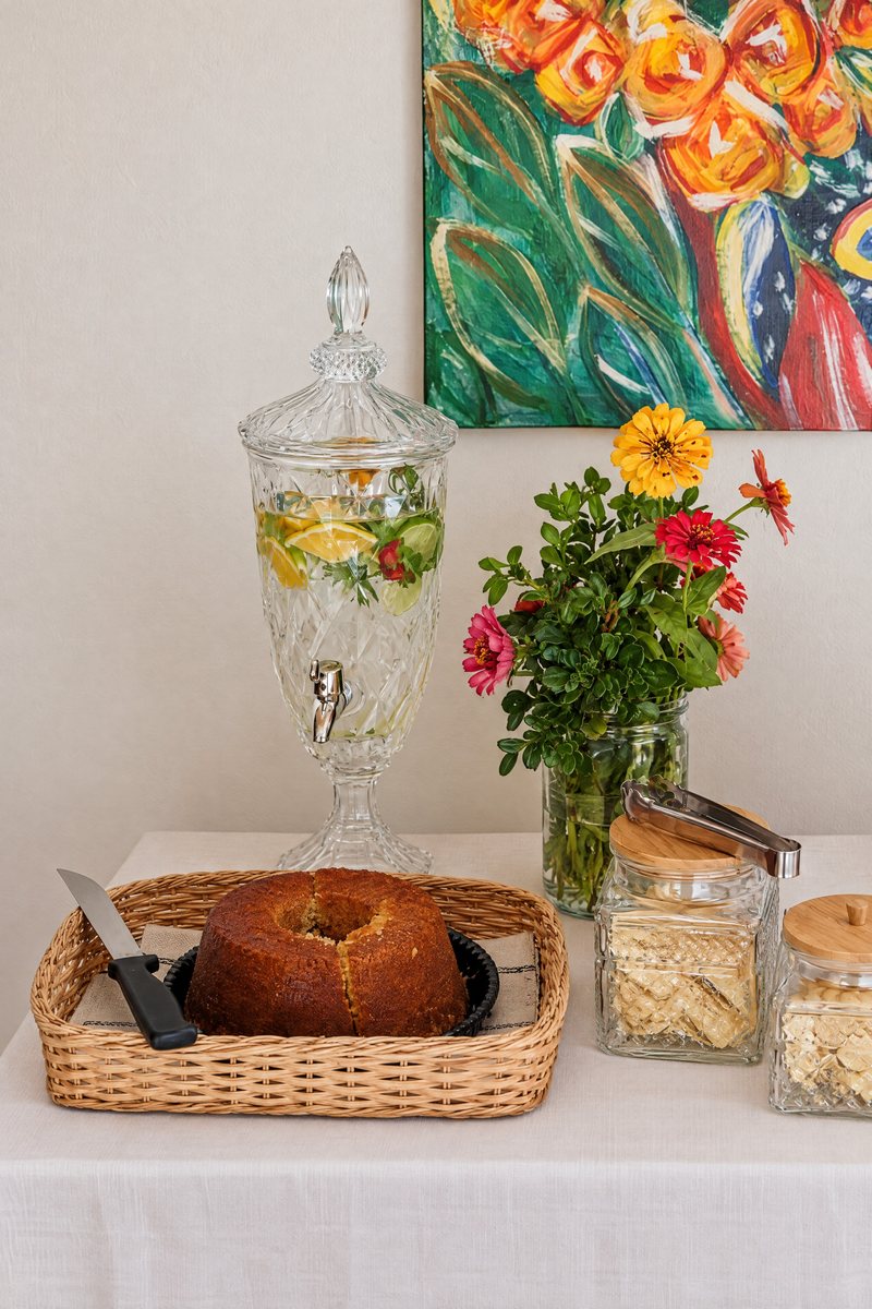 Mesa com pão, bolo e louça posta para o café da manhã