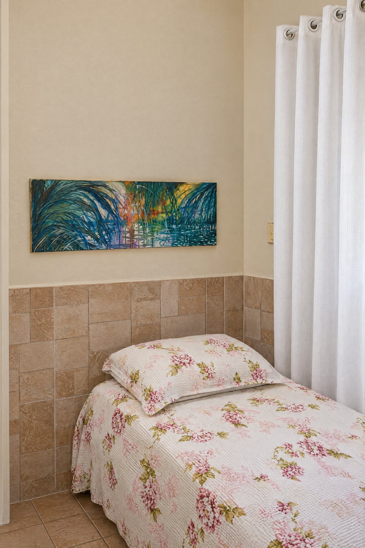 Cama com roupa de cama floral junto à janela